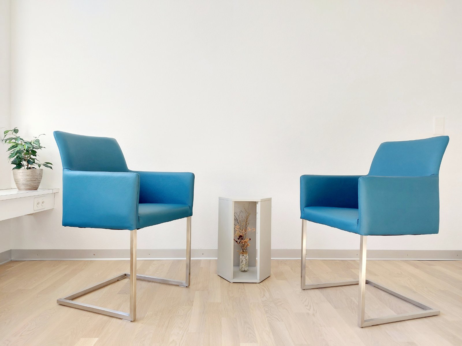 Zwei blaue Stuehle und ein kleiner Tisch in der Mitte
